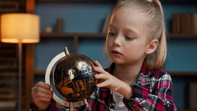 Cute clever little Caucasian child kid girl daughter spinning gold globe studying at evening home junior schoolgirl exploring world search countries learning study dreaming trip traveling concept - Powered by Shutterstock - Get 15% off with code: PIKWIZARD15