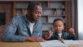 African American family father teaching little son kid boy helping child with writing homework assistance preparing test distant studying education from home learning talking together childcare study - Powered by Shutterstock - Get 15% off with code: PIKWIZARD15