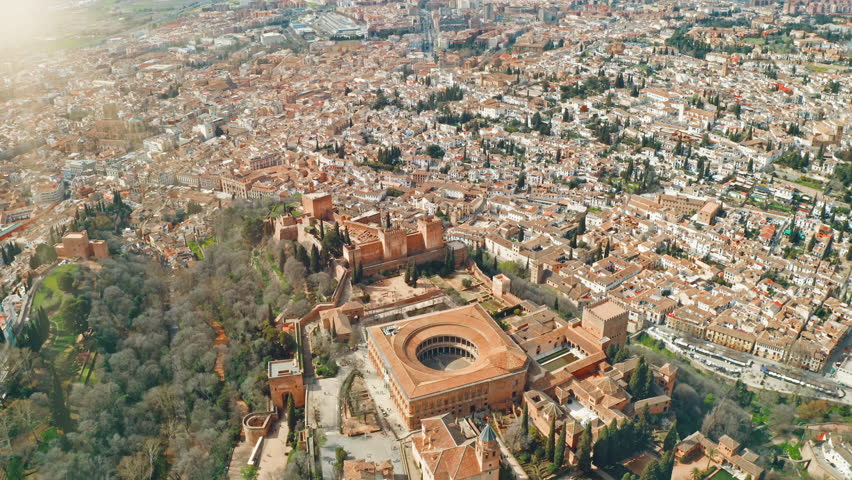 Granada Spain aerial top view of Alhambra with Palace of Charles V circular courtyard historic Andalusian fortress royal gardens surrounded by city rooftops cultural heritage landscape travel tour