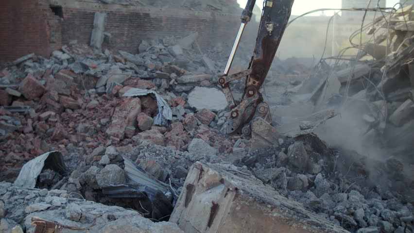 Excavator bucket removing rubble after demolition