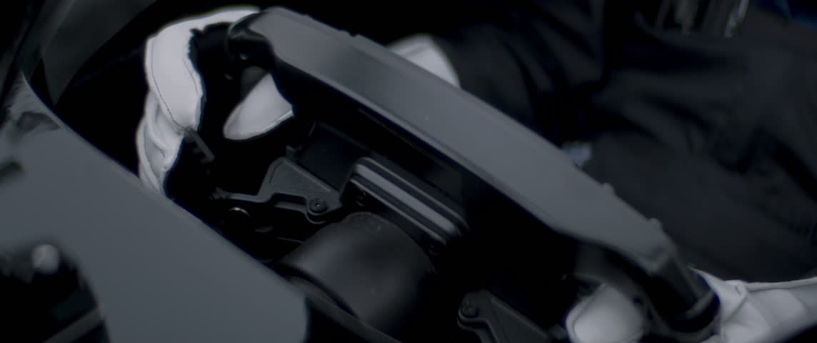 Close-up of a race car driver in white gloves driving fast on a racing track, evening race