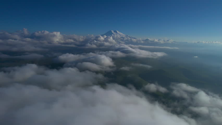 A view of the snow-capped peaks of Mount Elbrus above the clouds. Landscape and nature of the North Caucasus