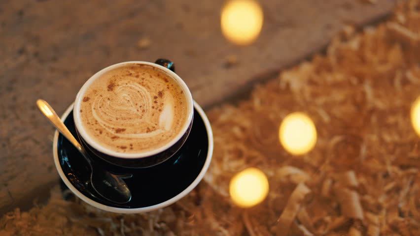 An inviting outdoor cafe setting showcasing cappuccino amidst fall leaves and soft bokeh lights