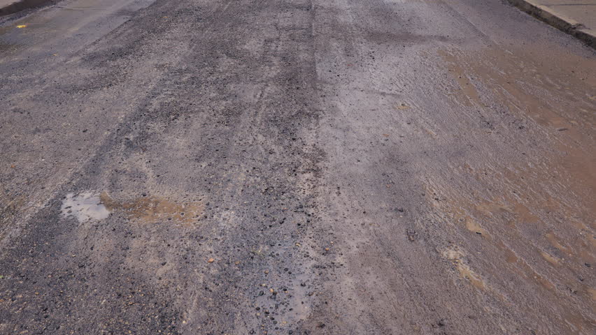 Wet asphalt with puddles and oil sheen, Recently rainwet asphalt with puddles and rut marks