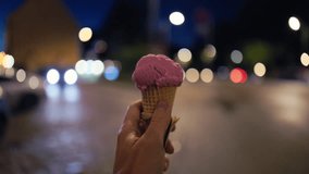 Pink gelato amid city lights, Handheld pink ice cream with city lights and rainy street ambiance - Powered by Shutterstock - Get 15% off with code: PIKWIZARD15