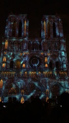 Notre Dame Cathedral in Paris illuminated during a vibrant light show at night, highlighting Gothic architecture, dramatic colors, and the iconic French landmark.