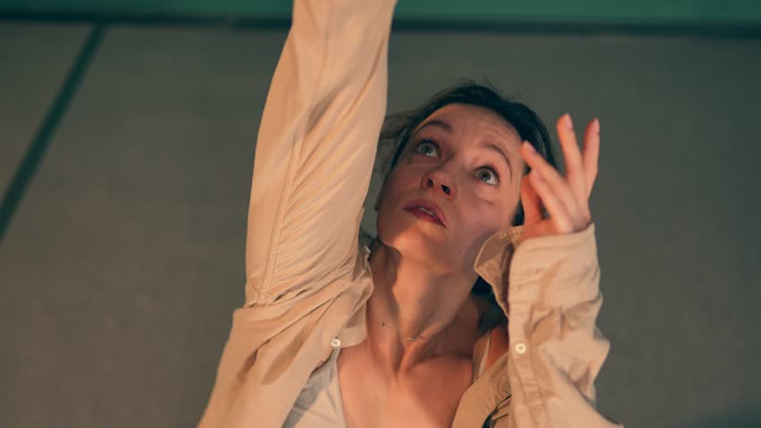 Woman is showing dynamic movement as she practices with passion and skill for new choreography performance. Artistic Caucasian lady is dancing alone in the studio in modern freestyle. Hobby time