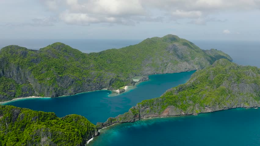 A beautiful natural nature under the clear blue sky and clouds. Aerial view of Tapiutan Island and Matinloc Island. El Nido, Palawan. Philippines.