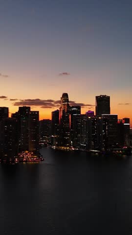 Aerial view of big city at night from above at dusk. Vertical video.