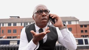 Man in formal attire talks on phone with a confused expression in a city setting - Powered by Shutterstock - Get 15% off with code: PIKWIZARD15