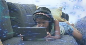 Child swiping tablet on couch wearing headphones hearing education audio showing glitch and smiling. Technology, entertainment, relaxation, modern, youth, digital, leisure - Powered by Shutterstock - Get 15% off with code: PIKWIZARD15