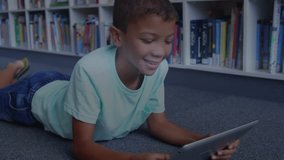 Boy propping on elbows scanning tablet and generating data charts code waveforms for education. Children, technology, innovation, digital, interactive, education, futuristic - Powered by Shutterstock - Get 15% off with code: PIKWIZARD15