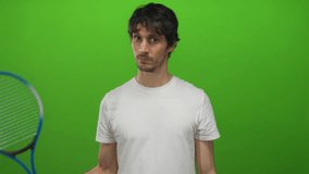 Young tennis player holds blue racket with wristband in green studio under bright lights with steady grip; focus. - Powered by Shutterstock - Get 15% off with code: PIKWIZARD15