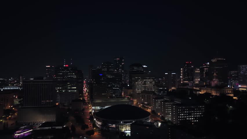 Nashville, Tennessee city skyline and streets at nighttime including Capitol Hill and the State Capitol Building - sliding aerial reveal