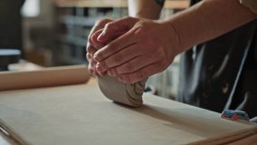 Hands of female potter wedging clay on worktable in ceramics studio, preparing material for wheel throwing. Close-up view - Powered by Shutterstock - Get 15% off with code: PIKWIZARD15