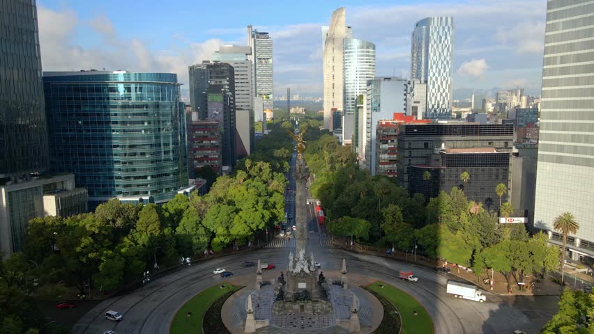 Tilt-down aerial view of the Angel of Independence on Paseo de la Reforma, commemorating the war in Mexico City, with a panoramic view of the Mexican capital.