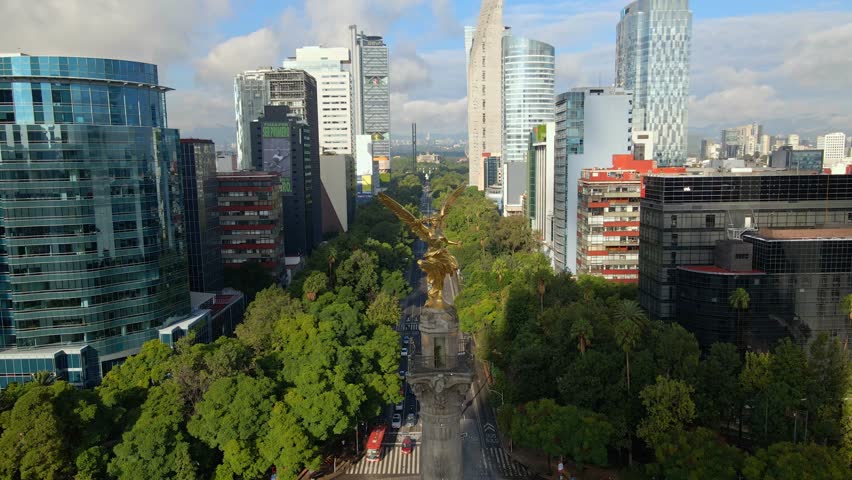 Aerial view dolly out detail of the Angel of Independence on Paseo de la Reforma in Mexico City CDMX, sunny workday with little traffic