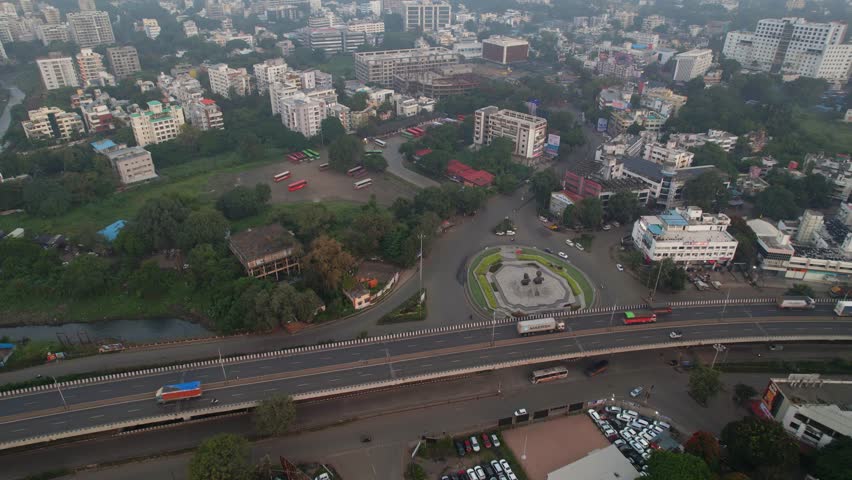 Tier 2 Nashik city residential and commercial highrise building apartments, Mumbai Naka circle with MSRTC bus stop, Maharashtra, Aerial pullback