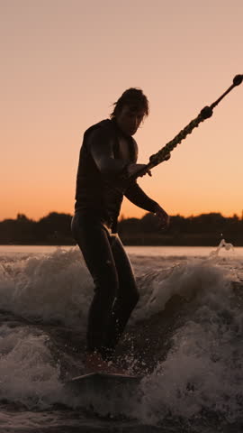 Dynamic Surfing Adventure: A Silhouette Catches the Waves at Sunset, Showcasing Skillful Maneuvers and the Beauty of Water Sports in a Vibrant Setting