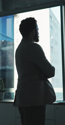 Thinking, man and arms crossed at window in office for architecture, career ambition and buildings. Below, architect and property development, urban infrastructure and reflection for town expansion