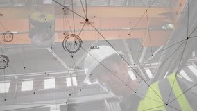 Factory tech under crane operating touchscreen showing network overlay for load monitoring. Industrial, automation, digital, technological, engineering, manufacturing, innovation - Powered by Shutterstock - Get 15% off with code: PIKWIZARD15