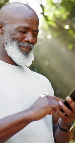 Senior black man, phone or fitness outdoor for research, social media and exercise progress. Below, elderly person or bokeh with mobile, training website and browsing internet for sports blog at park
