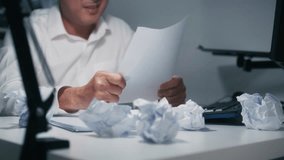 Close-up of Asian Businessman Manager Hand Crumpling Paper ball. Upset, Anxious Asian Businessman making mistake, Feels Burnout, Failure Crumpling business paper and Throw away sit at desk in office. - Powered by Shutterstock - Get 15% off with code: PIKWIZARD15