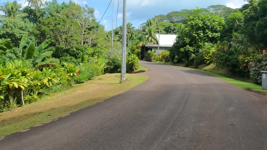 French Polynesia. Driving on Road on Island, Tropical Lush and Local Home Point of View