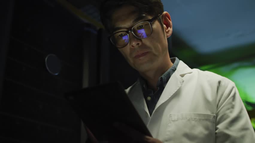 Male scientist in data center gazing tablet, causing binary digits spreading and confirming result. Technology, innovation, cybersecurity, data analysis, digital, futuristic, analytical - Powered by Shutterstock - Get 15% off with code: PIKWIZARD15