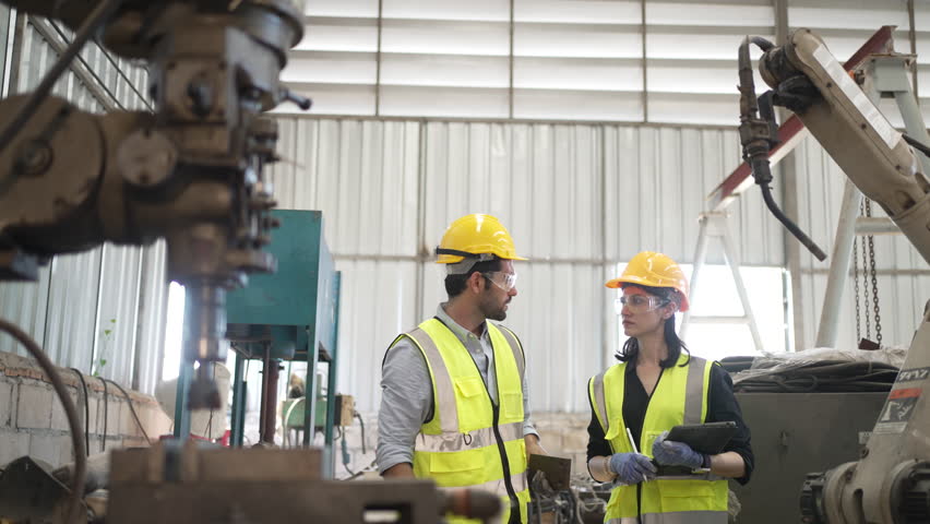 Blue collar workers at machine shop with coring machine. Factory and machinery.