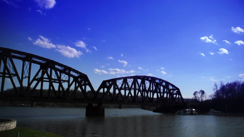 Time lapse clouds over a railroad bridge.