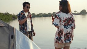 Asian couple or close friends standing and chatting by the lake, enjoying beer and a relaxing summer evening during their adventurous camping trip - Powered by Shutterstock - Get 15% off with code: PIKWIZARD15