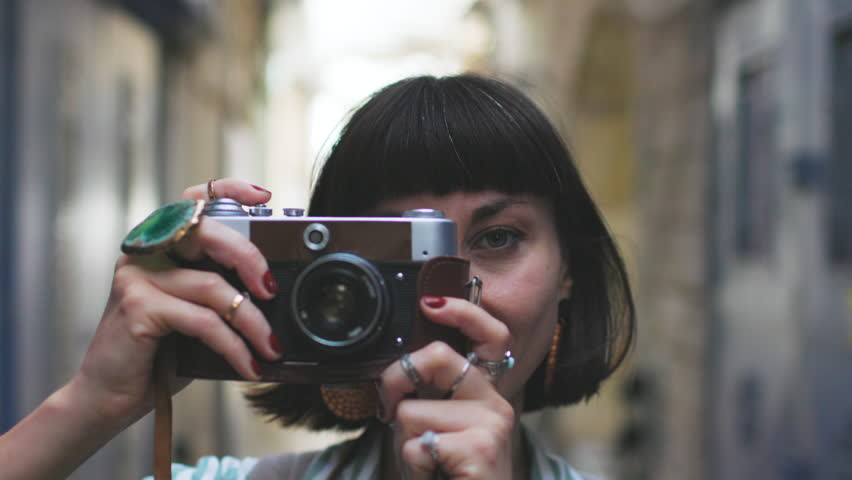 A female photographer with a camera. A young photographer enjoys taking photos. Traveling to Arab countries. Travel and vacation.