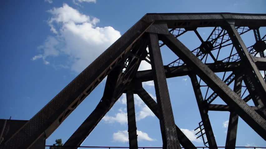 Time lapse clouds over a railroad bridge.