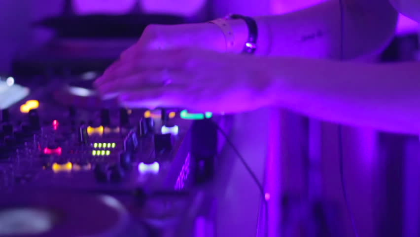 Young woman DJ in night club performs her set