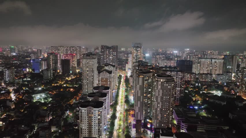 Bright night view of Hanoi high-rise boulevard lined with lights and modern buildings.