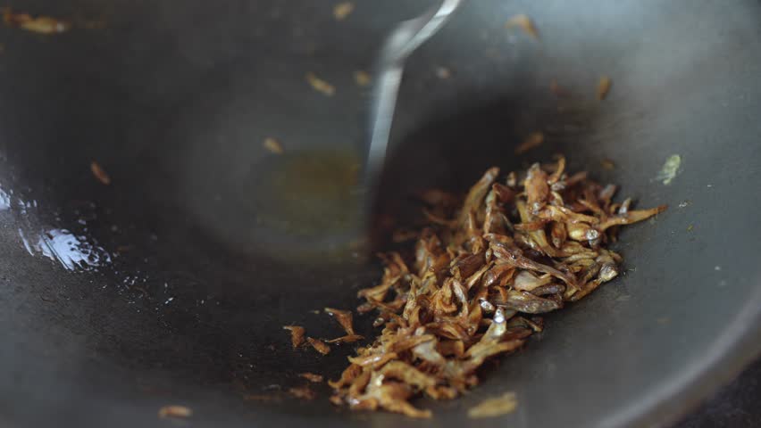 Fried Shallots in Wok Creating Rich Aroma and Golden Brown Crunch, Enhancing Culinary Flavor in Dishes with Crispy Fried Fish and Savory Ingredients for Perfect Cooking