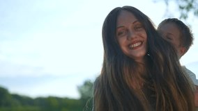 Parent giving son piggyback ride sunny park. Smiling son enjoying playful moment with parent outdoors. Joyful family time, parent bonding with son in park. Happy son and parent piggyback ride nature. - Powered by Shutterstock - Get 15% off with code: PIKWIZARD15