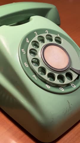 Retro Rotary Telephone Handset Picked Up Under Warm Lamp Light, closeup, vertical