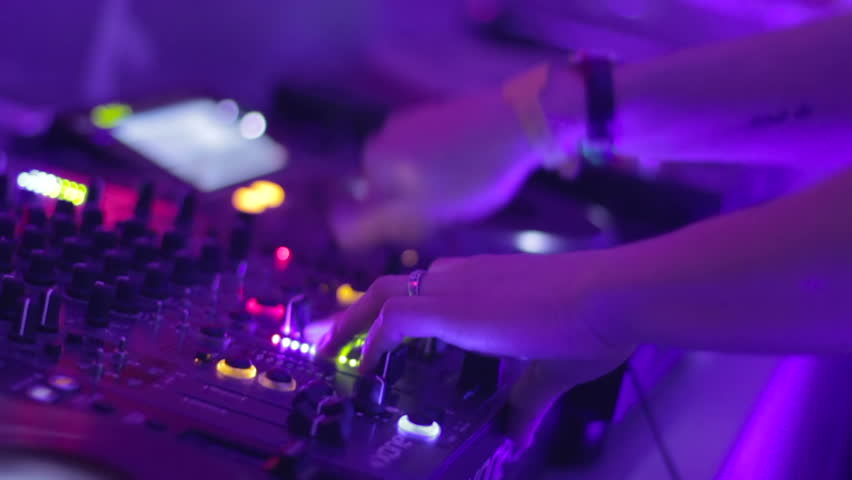 Female Dj hands playing set in night club party