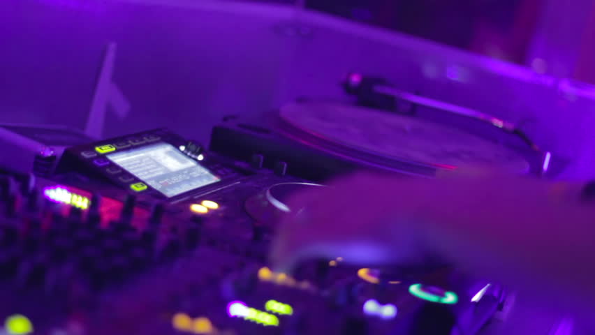 Fast rhythmic hand movements of DJ in night club