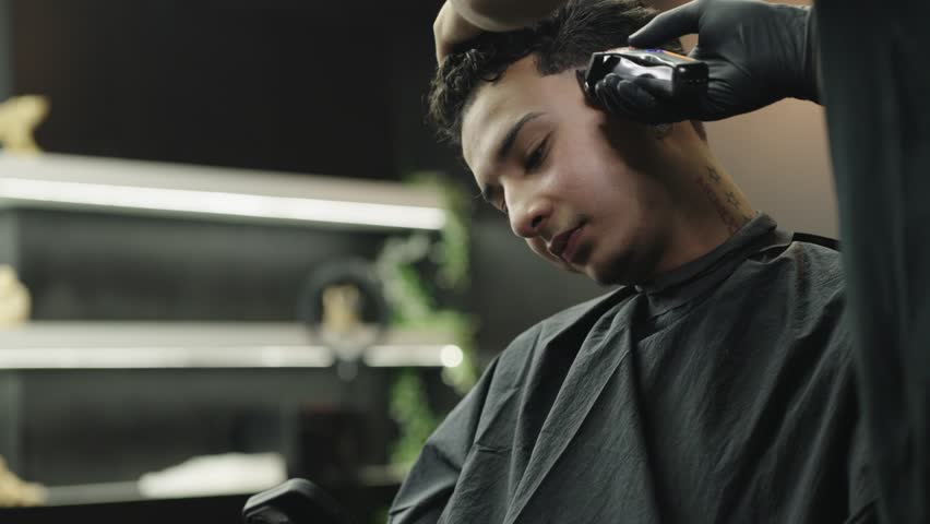 Barber giving a man a fade haircut with clippers