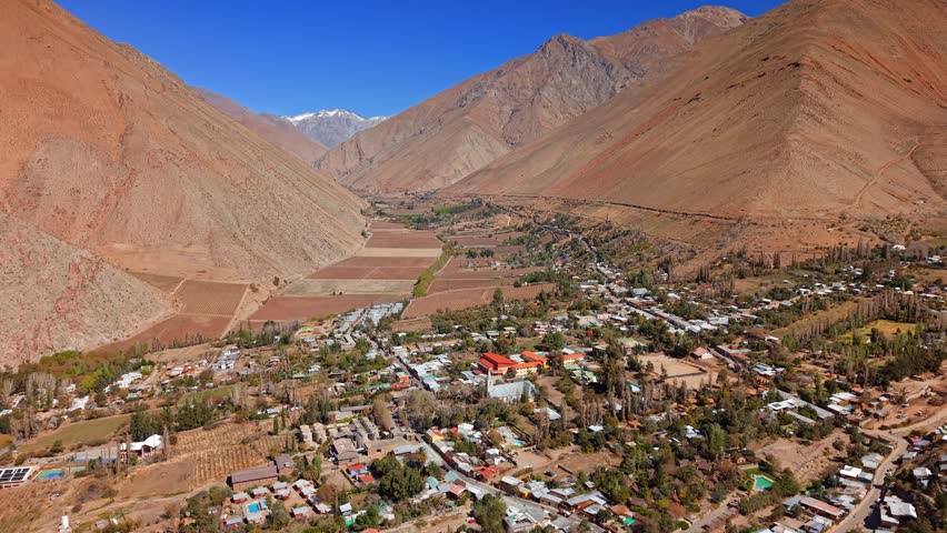 Aerial reveals Elqui Valley town in Chile, Pisco Vineyards, Andean Cordillera mountain landscape. Pisco Elqui town