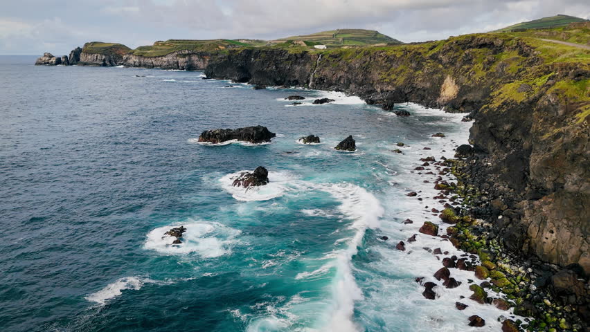 Rocky coastline with sea reefs cliffs on volcanic Sao Miguel Island, Azores. Atlantic Ocean shoreline of volcanic origin
