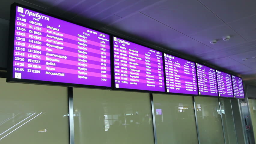 Flight arrivals and departures info screens on screen monitor in airport lobby
