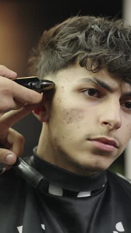 Professional barber giving fade haircut with electric trimmer