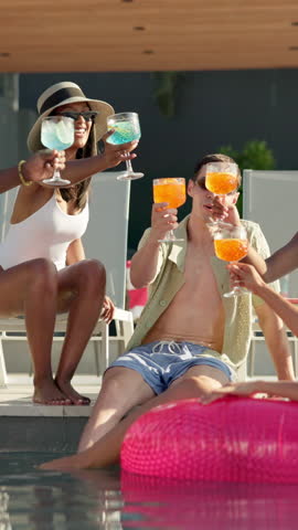Toast, party and friends with holiday in swimming pool for weekend, break or vacation. Relax, sunglasses or group in water with smile, alcohol and people at hotel or lodge resort for summer getaway