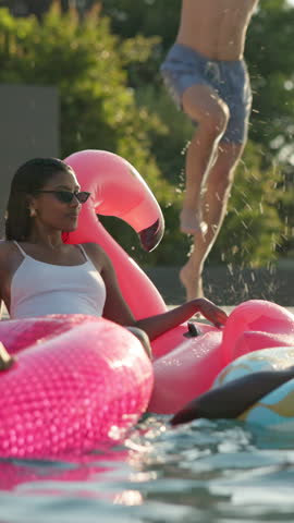 Pool party, splash and friends on holiday for fun, playful and bonding at resort. Woman, student group and water on vacation for reunion, spring break and float at luxury accommodation for relax