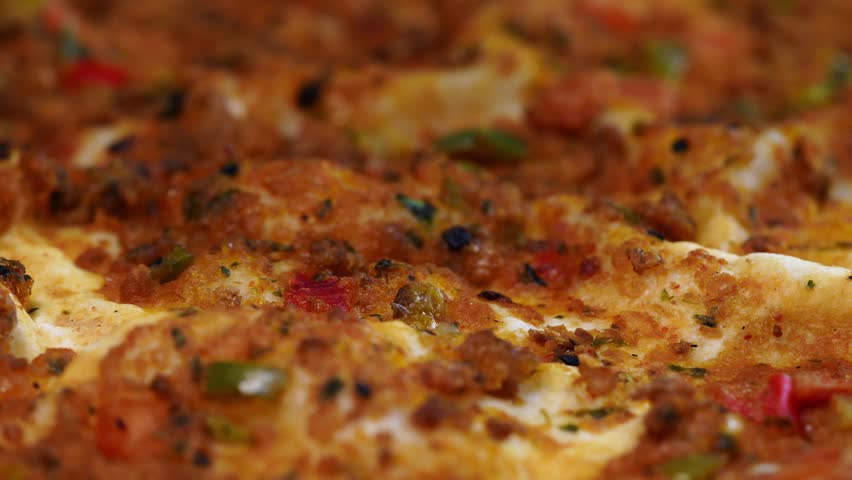 Minced meat lahmacun. 4K macro shot of traditional Turkish lahmacun. Hot and crispy lahmacun with minced meat and fresh herbs. 