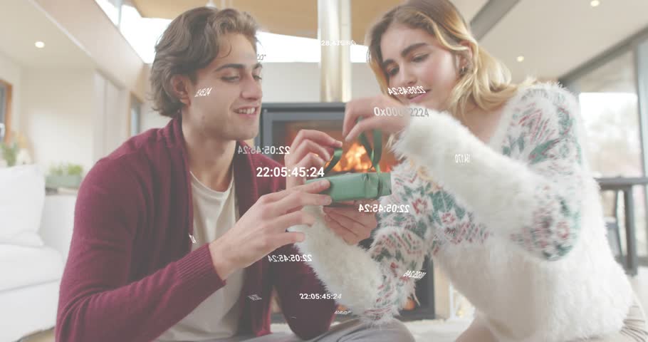 Couple sitting by fireplace woman lifting lid causing animated hearts circling box for gift ads. Romance, intimacy, warmth, celebration, affection, modern, cozy